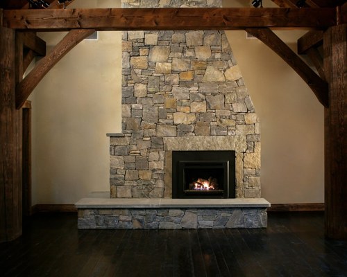 Floor-to-ceiling natural stone veneer fireplace in a vaulted interior