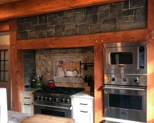Natural stone veneer kitchen accent wall with wood beams