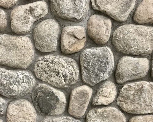 Rounded fieldstone veneer with weathered New England character