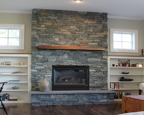 Vermont Verde Mica thin stone veneer fireplace surround in a living room.